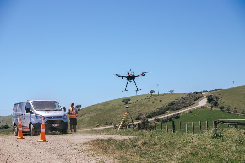 Drone just after takeoff on rural property with operator in background