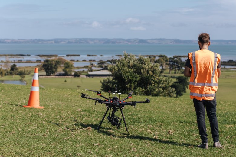 Drone on ground next to operator - harbour in distance