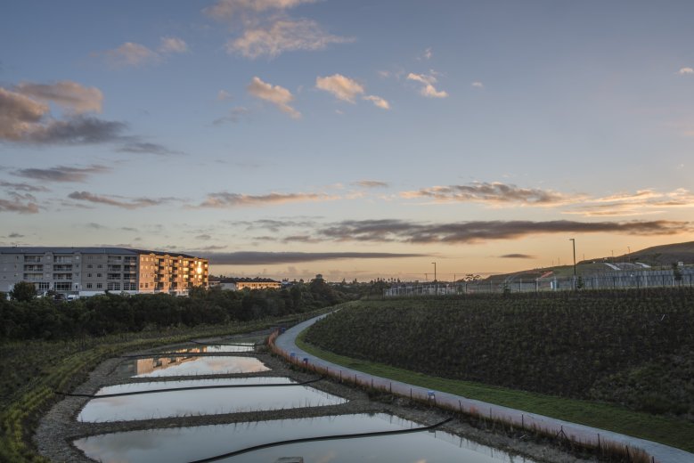 Retention pond with apartment block in background