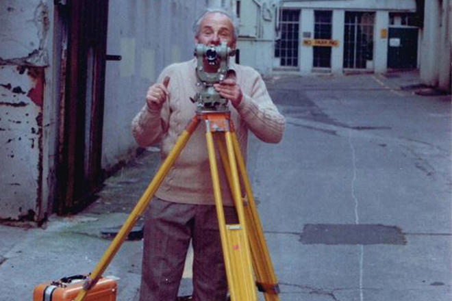 Man using survey equipment on street
